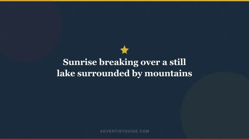 Sunrise breaking over a still lake surrounded by mountains